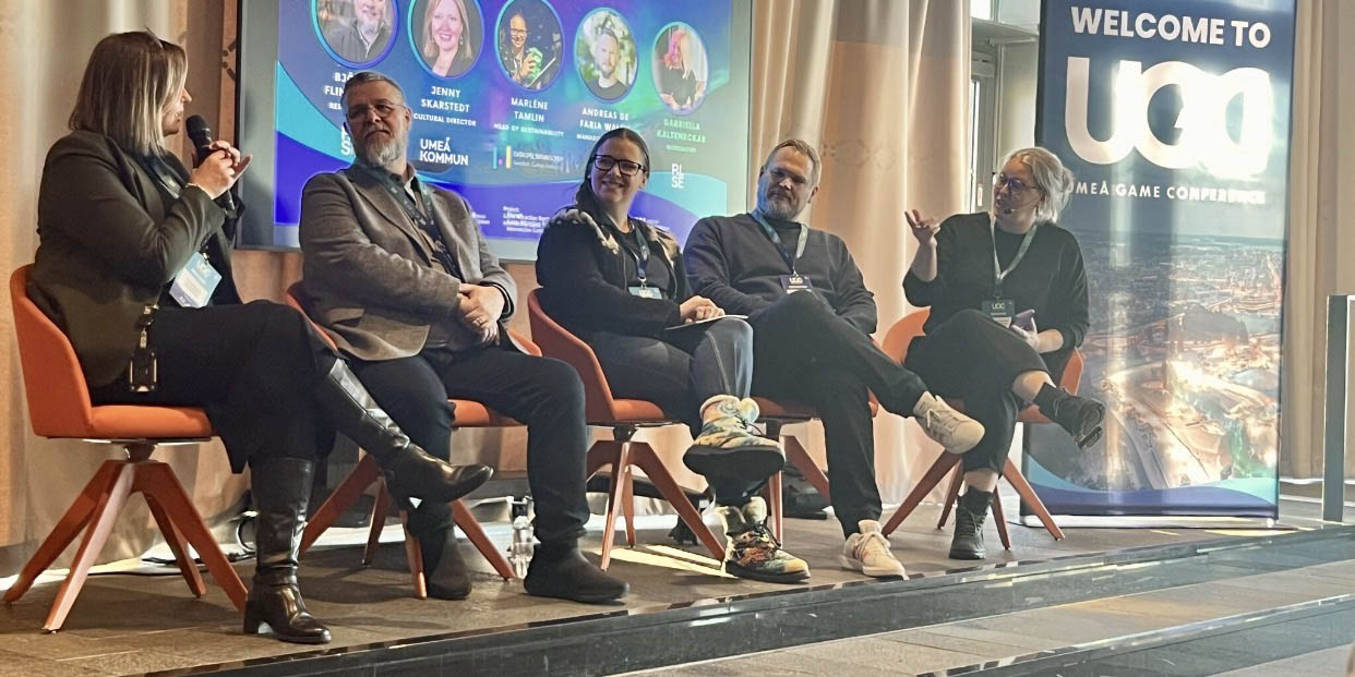 Panellists sitting on stage at gaming event